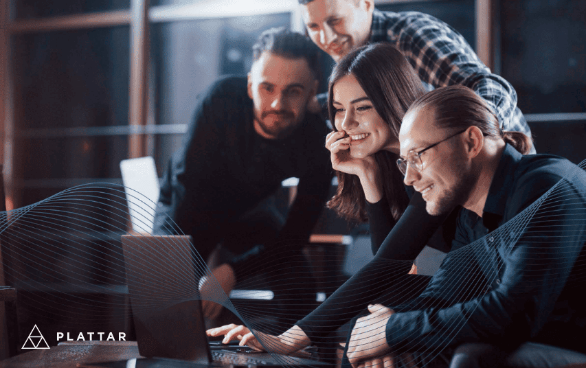 Four people viewing a laptop together.