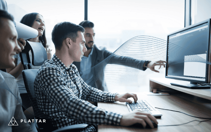 Four people viewing a desktop computer together.